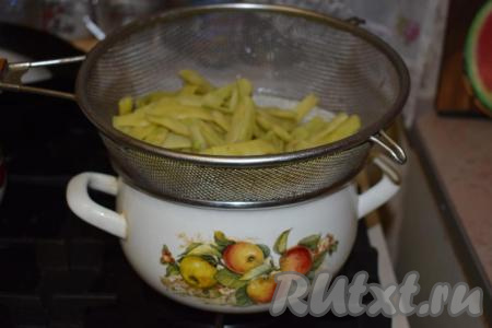 Затем сливаем воду через дуршлаг и даём отваренной фасоли немного стечь.