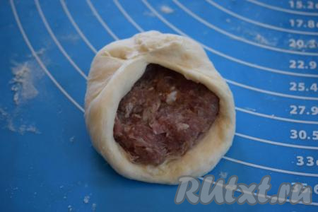 Далее начинаем защипывать тесто над мясной начинкой.