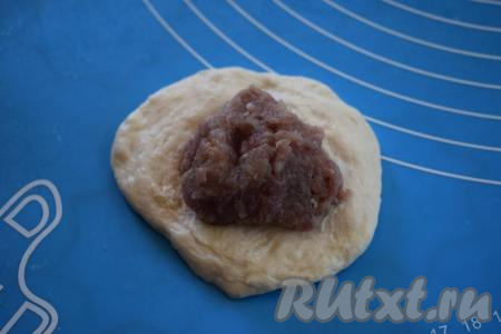 Берём шарик теста&nbsp;и раскатываем его скалкой в лепёшку диаметром, примерно, 12 см. На середину лепёшки кладём около 1 столовой ложки фарша.