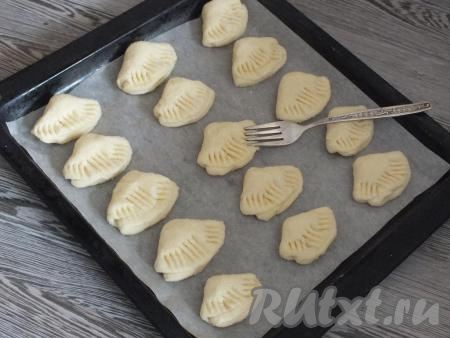 Выложите будущее творожное печенье на противень, застеленный пергаментом. Вилкой прижмите края печенья (как на фото), чтобы оно внешне напоминало "гусиные лапки". Поставьте противень в разогретую до 200 градусов духовку минут на 25. Учитывайте особенности своей духовки!