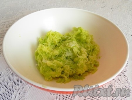 Рис промыть водой, выложить в кастрюлю с кипящей водой и отварить до готовности (в течение минут 20 с момента закипания, рисинки, должны стать в меру мягкими, но при этом хорошо держать форму), затем лишнюю жидкость слить, дать рису остыть.&nbsp;Кабачок очистить от кожуры. Если семечки крупные, их нужно удалить. Натереть очищенный кабачок на мелкой тёрке, посолить и оставить минут на 5-7, чтобы кабачок дал сок. Затем сок отжать и слить. Кабачковую массу, отжатую от лишней влаги, выложить в миску.