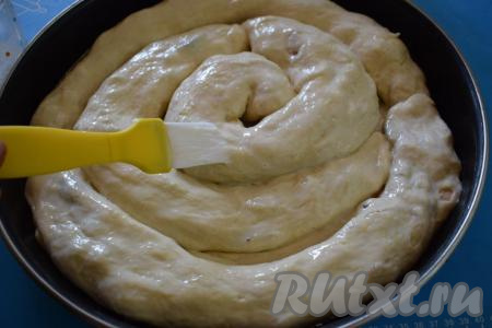 Форму застилаем пергаментом (или фольгой) и выкладываем наши трубочки с начинкой по кругу, формируя пирог, а затем смазываем его яйцом, смешанным со сливками (или молоком), при помощи кулинарной кисти.