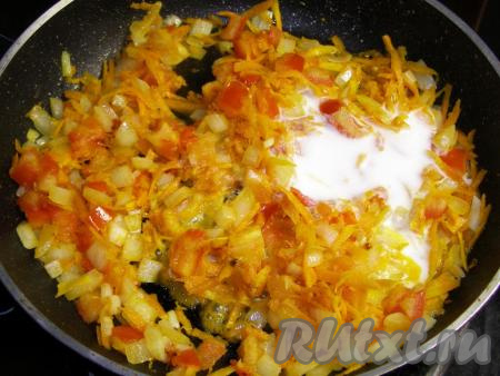 Кладём к обжаренным овощам сметану и перемешиваем.