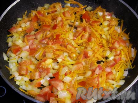 В подсолнечном масле обжариваем на среднем огне морковь с луком до мягкости (в течение минут 7), затем добавляем нарезанный помидор, перемешиваем и жарим, периодически помешивая, ещё пару минут.