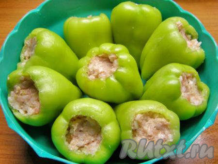 Каждый подготовленный перчик с помощью чайной ложки заполняем фаршем, смешанным с рисом, и слегка приминаем фарш.