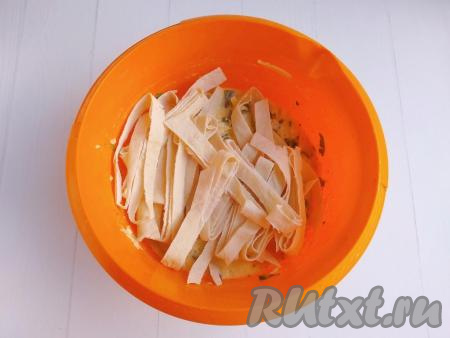 Лаваш свернуть в рулет, нарезать чистыми ножницами на полоски шириной около 8 см и тоже выложить в миску, перемешать.