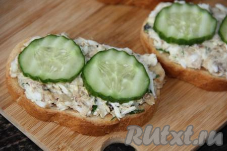 Огурчик вымыть и нарезать тонкими кружочками. Выложить пару кружочков огурца поверх начинки.