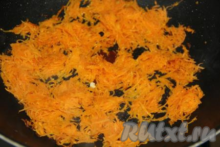 В сковороду, где жарили омлет, влить немного масла и добавить очищенную морковь, натёртую на мелкой тёрке. Обжарить морковку, помешивая, в течение нескольких минут на среднем огне.