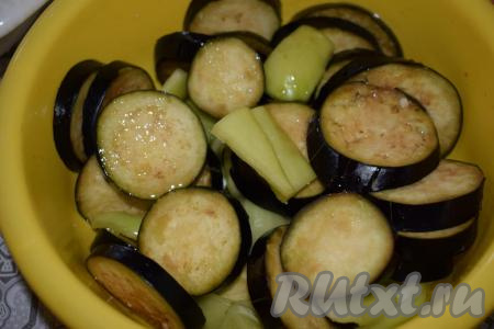 Далее в миску к баклажанам и перцам добавляем растительное масло и тщательно перемешиваем&nbsp;овощи, стараясь, чтобы масло покрыло всю их поверхность.