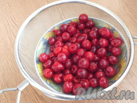 Приготовление королевской ватрушки с творогом и вишней начните с подготовки вишни. Ягоды необходимо вымыть, удалить из них косточки. Вишню, очищенную от косточек, выложить в дуршлаг и оставить на время, чтобы стёк сок.