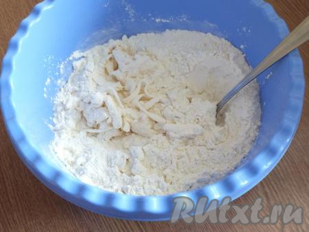 К натёртому маслу добавьте 1/2 стакана сахара, разрыхлитель и муку, перемешайте столовой ложкой.