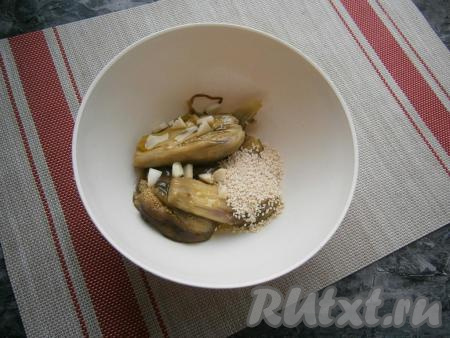 Поместить мякоть баклажанов в миску (или чашу блендера), добавить кусочки чеснока, всыпать кунжут.