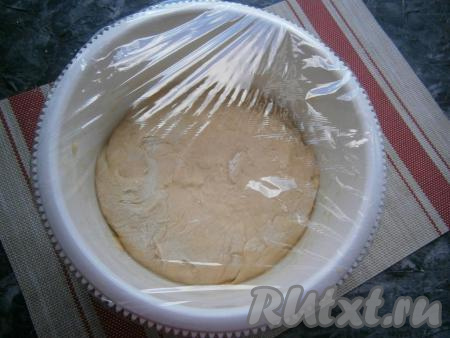 Немного подсыпая муку на стол, выложить и обмять полученное тесто. Оно будет мягким и немного липким. Тесто поместить в миску, смазанную растительным маслом, затем накрыть плёнкой и оставить в тёплом месте часа на 2.