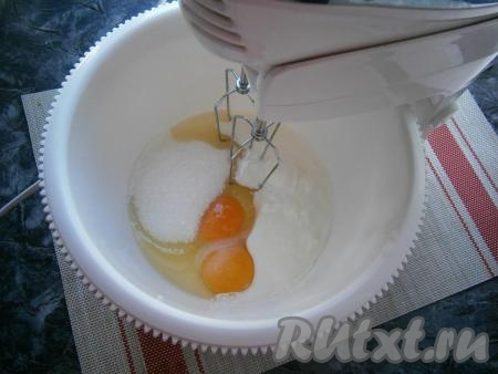 Я замешивала тесто миксером (можно, несомненно, замесить и в глубокой миске с помощью ложки). В&nbsp;чашу миксера (или в глубокую миску) поместить яйца, оставшийся сахар, соль, ванильный сахар, добавить йогурт комнатной температуры. Йогурт можно заменить на кефир или ряженку.