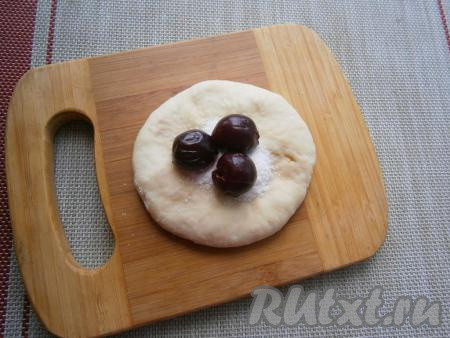 Каждую часть теста немного приплюснуть в лепёшку, в середину которой поместить по 3-4 ягодки вишни, всыпать&nbsp;0,5&nbsp;чайной ложки&nbsp;смеси крахмала и сахара.