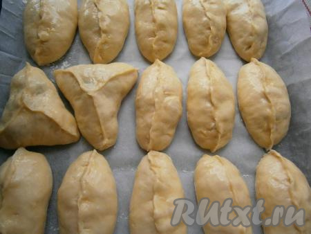 Сформировать пирожки любым удобным для вас способом, лучше стороной с защипами кверху. Выложить пироги на противень, застеленный пергаментом, и смазать яйцом, взбитым с водой и 0,5 чайной ложки сахара.