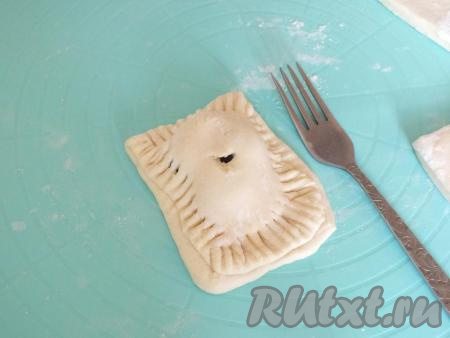 Накройте начинку свободной половинкой теста, как книжку. С помощью вилки соедините края. Сделайте отверстие в центре слойки.