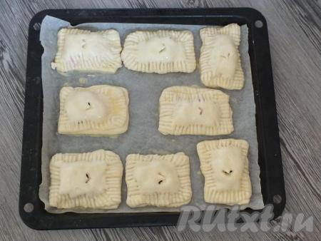 Подготовленные слойки выложите на противень, застеленный пекарской бумагой. Смажьте верх выпечки взбитым яйцом. Поставьте выпекаться в разогретую до 180 градусов духовку на 25 минут. Ориентируйтесь на свою духовку!