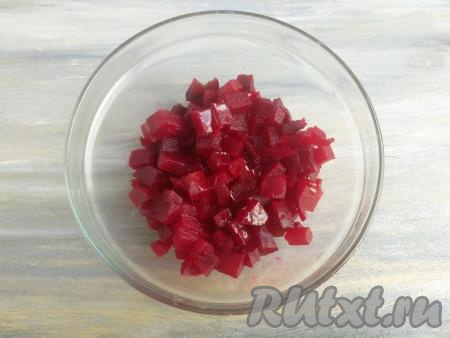 Отварную свеклу нарезать кубиками размером по&nbsp;0,5 см, а затем выложить в отдельную миску, добавить чайную ложку растительного масла, перемешать.