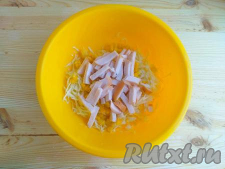 Ветчину нарезать тонкими брусочками и выложить в салат из капусты и кукурузы, перемешать.