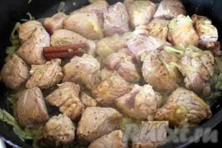 Свинину нарежьте на кусочки и добавьте на сковороду к луку и пряностям, обжарьте со всех сторон до полуготовности.