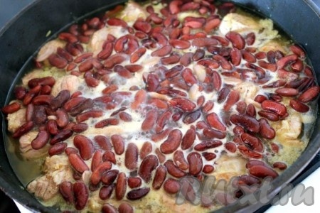 Добавьте 2/3 стакана горячей воды и практически готовую красную фасоль к свинине, потушите всё вместе около 20 минут на среднем огне под крышкой.