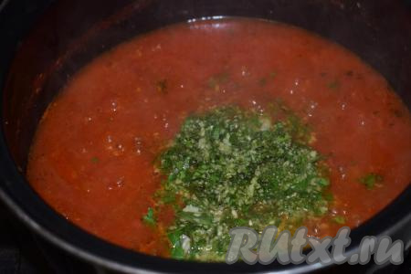 Измельчённые чеснок, базилик и петрушку выкладываем в кастрюлю с томатной массой и перемешиваем.