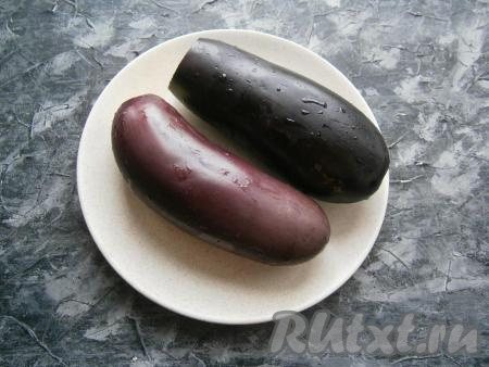 Яйца выложить в небольшую кастрюльку, залить холодной водой и отварить с момента закипания воды в течение 8-10 минут, затем остудить их и очистить. Вымыть баклажаны и отрезать у них хвостики.