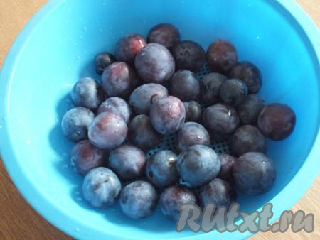 Сливы вымойте, выложите в дуршлаг, чтобы стекла лишняя жидкость. Затем, разделив сливы на две половинки, извлеките косточки.