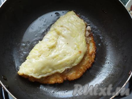 Накройте фарш свободной частью блинчика, прижмите слегка лопаткой и обжаривайте с каждой стороны по 3-4 минуты под крышкой.