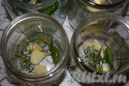 На дно каждой банки выкладываем по 2 зубчика очищенного чеснока, нарезанного на пластины, а также четверть большого укропного зонтика и пару листиков базилика.