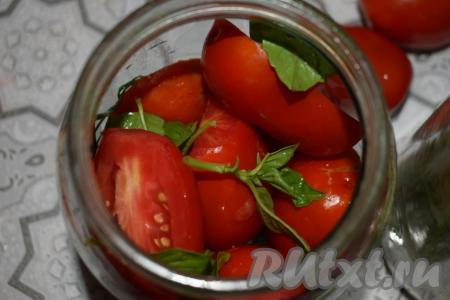 Кладём на дно каждой банки по 2 кружочка лука. Заполняем каждую баночку половинками помидоров&nbsp;и листиками базилика, в середину выкладываем&nbsp;пару колечек лука и продолжаем заполнять банку до самого верха помидорами и листочками базилика.