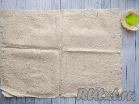 Лаваш разложить на стол и смазать тонким слоем майонеза, немного не доходя до краёв лаваша.