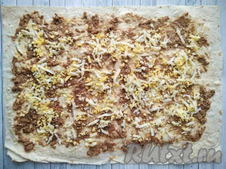 Поверх тунца выложить яйца, натёртые на крупной тёрке.