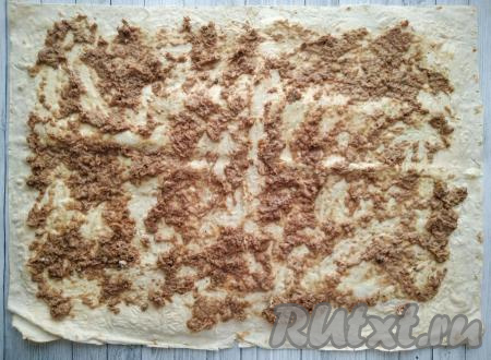 Далее на смазанный лаваш равномерно распределить консервированного тунца, по-прежнему оставляя края лаваша чистыми.