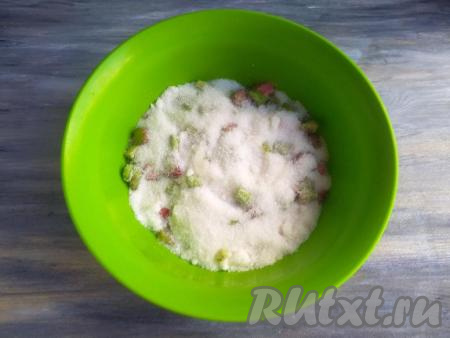 Выложить нарезанные стебли ревеня в миску, засыпать сахаром и оставить на 4-5 часов при комнатной температуре.