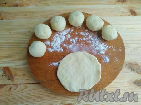Разделить тесто на 7 частей, скатать в небольшие шарики и выложить на дощечку, посыпанную мукой.&nbsp;Каждую часть раскатать в лепёшку толщиной 2 мм.