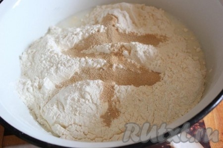 Затем добавьте муку с дрожжами и замесите тесто.