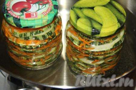 Прикрыть банки крышками и поставить в кастрюлю, дно которой застелено тряпочкой, сложенной в несколько раз (баночки будут стоять на тряпочке, не соприкасаясь с дном кастрюли, а значит они не лопнут в процессе стерилизации). Влить в кастрюлю горячую воду, которая должна доходить до плечиков банок, заполненных кабачками с морковкой в маринаде.
