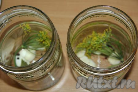 Баночки вымыть, а затем простерилизовать (я стерилизую в посудомойке). На дно каждой подготовленной банки выложить 3-4 очищенных и разрезанных на несколько частей зубчиков чеснока, 1 зонтик укропа, 1 лавровый листочек, 4-5 горошинок чёрного перца.