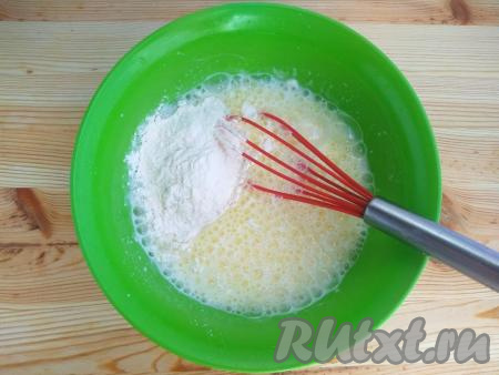 Добавить просеянную муку, тщательно перемешать венчиком, замешивая тесто.