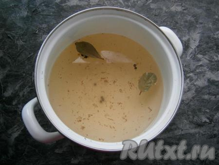 По истечении времени воду из банок снова вылить в кастрюлю, добавить чёрный перец горошком, щепотку корицы, соль, лавровый лист, сахар, поставить на огонь, после закипания проварить минуты 2, чтобы кристаллики сахара с солью полностью растворились в кипящей воде, после этого влить яблочный уксус и снять маринад с огня.