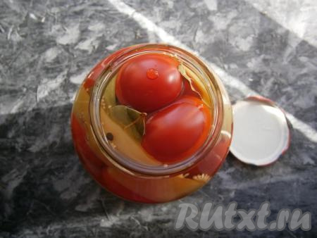 Второй раз воду из банки слить в раковину и сразу влить в банку с помидорами и перцем горячий маринад, полностью покрывая им овощи.