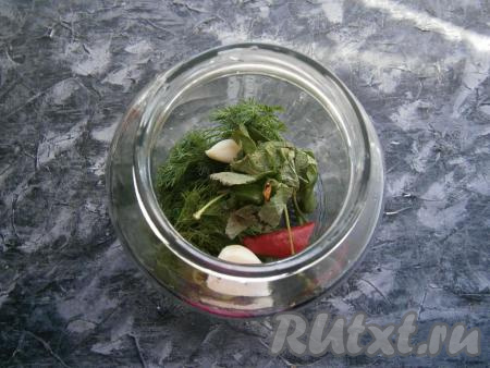 В чисто вымытую банку выложить укроп, чеснок, горький перец, листья чёрной смородины.