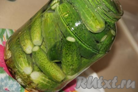 Залить горячим маринадом огурцы в банке, заполняя баночку маринадом до самого верха.