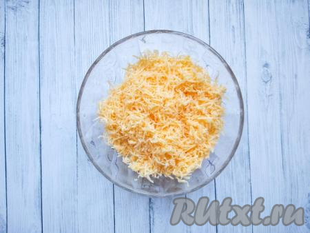 Натереть на мелкой тёрке сыр твёрдых сортов, затем разделить его мысленно на 2, примерно, равные части: часть сыра станет начинкой для рулетиков, а второй частью сыра будем посыпать куриные рулетики в конце запекания.