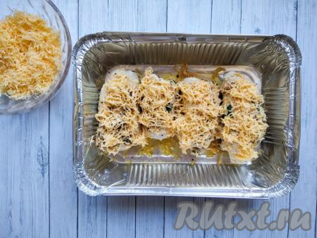 Затем достать форму для запекания из духовки, смазать рулетики из куриного филе майонезом, посыпать оставшимся твёрдым сыром и поставить в духовку на 5 минут.