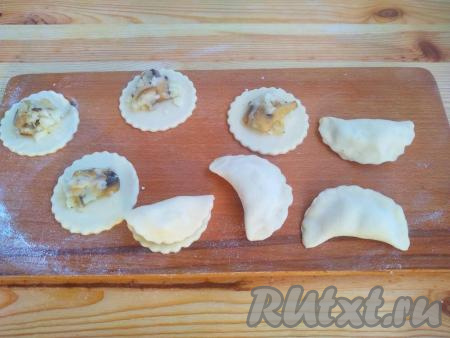 Выложить по 1 чайной ложке начинки в центр каждого кружка и крепко слепить края каждого кружочка, формируя вареник с картофельно-грибной начинкой.