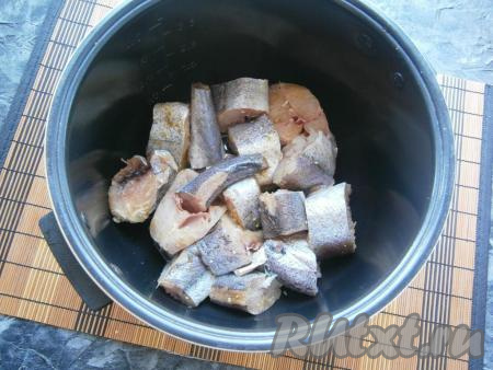 Хека разморозить, если неочищенный - очистить, отрезать плавники, удалить внутренности и чёрную плёночку из брюшка, хорошо промыть. Нарезать рыбу кусочками шириной около 3-4 см, посолить, посыпать специями, выложить в чашу мультиварки.