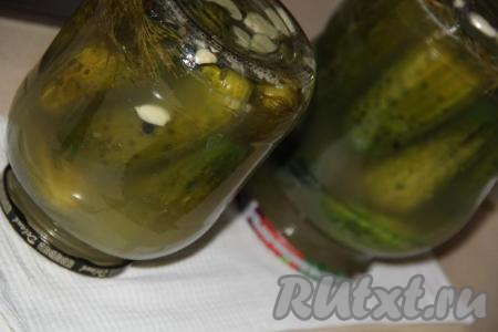 Закрыть простерилизованными крышками (я прокипятила крышки в течение 3 минут). Перевернуть баночки с огурчиками вверх дном, со всех сторон укутать в одеяло и оставить укутанные банки до полного остывания.
